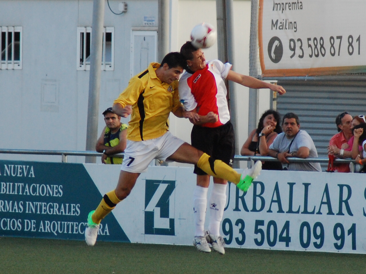 Poves salta de cap amb un jugador del Rubí intentant refusar la pilota. FOTO: Jordi de Planell.