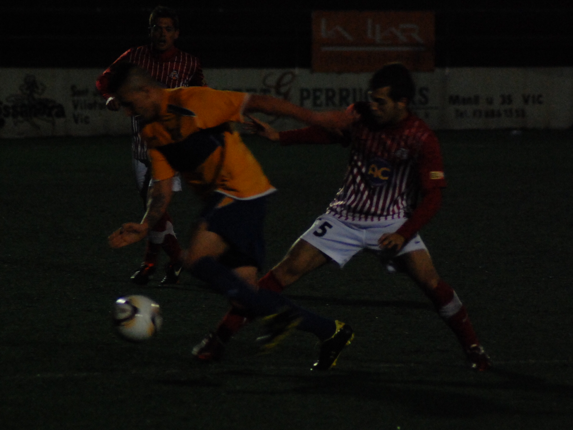 Pol Coll disputa l'esfèrica. El partit es va jugar a la nit, cosa poc habitual i que no va ajudar a la presència de públic. FOTO: Jordi de Planell.