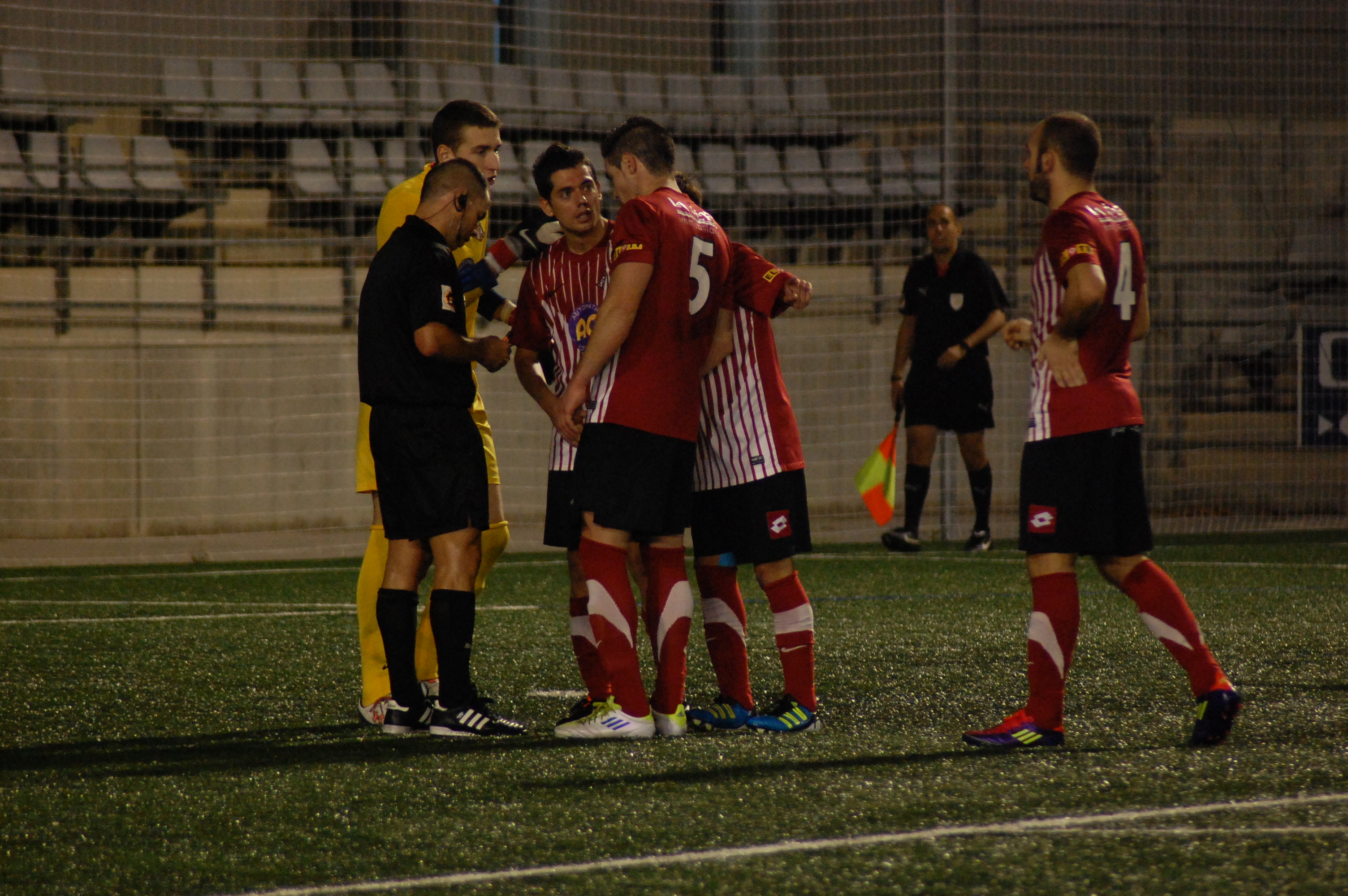 Els jugadors del Vic protesten a l'àrbitre el penal que ell acabava de xiulari que allargava, una jornada més, el robatori arbitral als vigatans. (FOTO: Jordi de Planell)